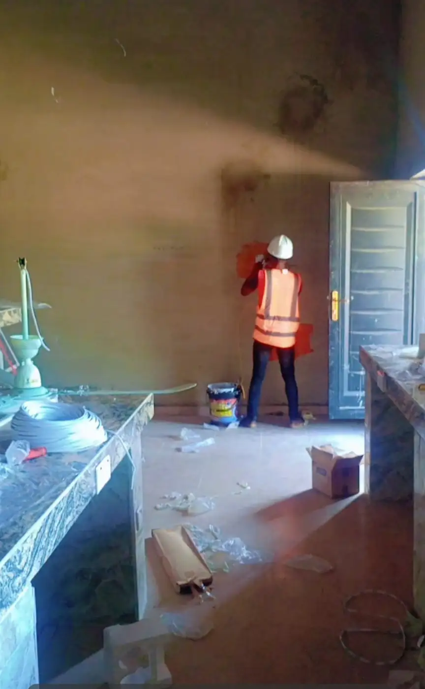 Painter in protective gear finishing a wall