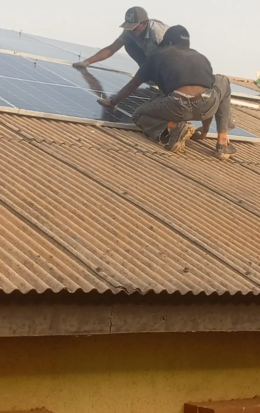 Two installers laying a panel on corrugated roofing