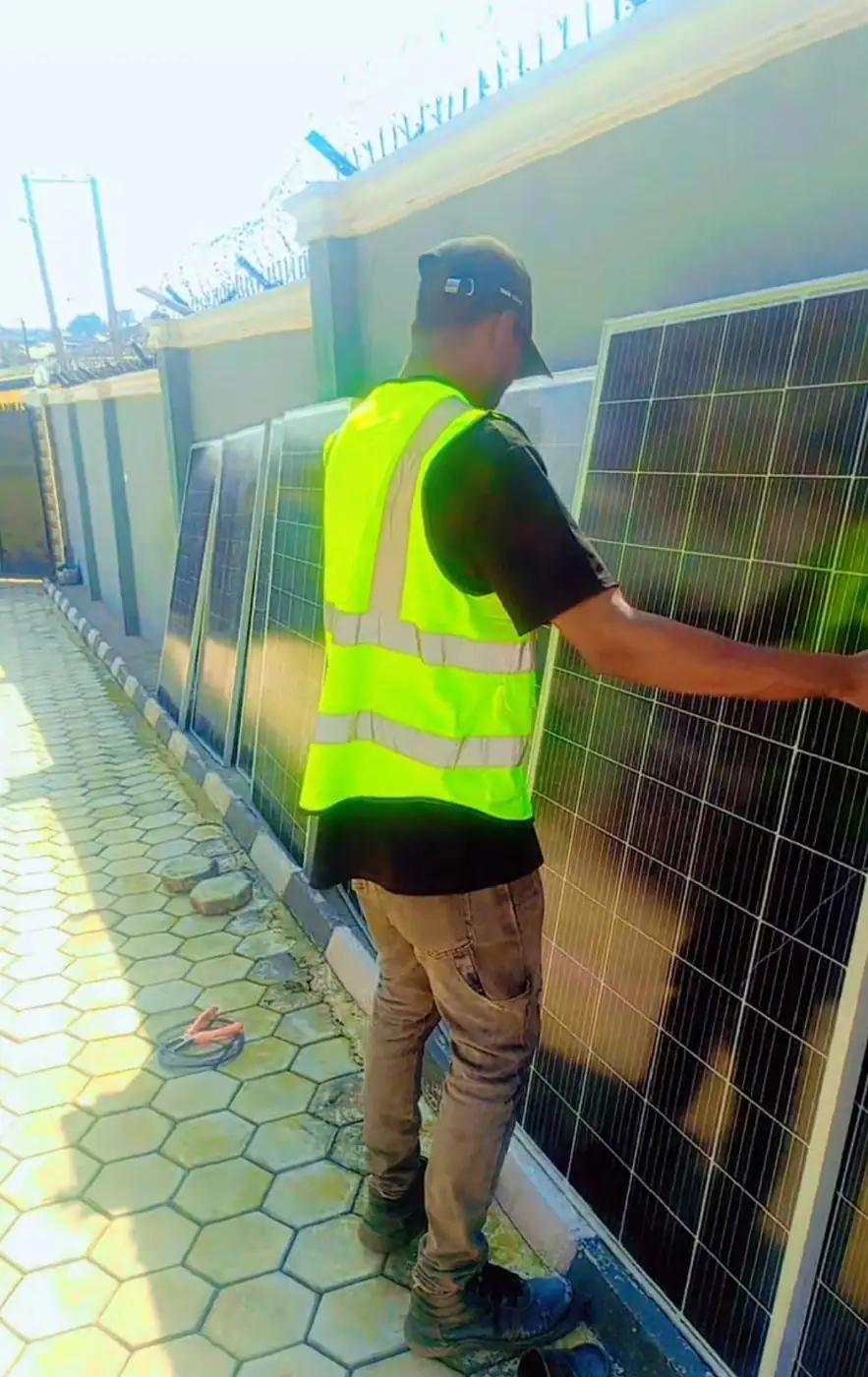 Installer checking a panel, in high-visibility vest