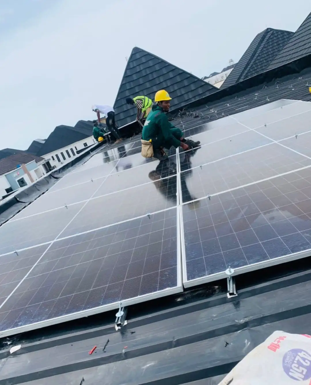 Installers fitting panels on a stone-coated roof